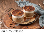 Indulge in a luscious tiramisu-inspired chia pudding, layered with creamy coffee-infused chia and a rich chocolate topping. This delightful breakfast or dessert option combines classic tiramisu flavors with wholesome ingredients for a convenient and satisfying treat. Стоковое фото, агентство Ingram Publishing / Фотобанк Лори