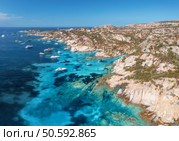 Breathtaking aerial view capturing luxury yachts moored along the rocky coastline of la maddalena archipelago in sardinia island, revealing vibrant turquoise waters. Top view of boats and blue sea. Breathtaking aerial view capturing luxury yachts moored along the rocky coastline of la maddalena archipelago in sardinia, revealing vibrant turquoise waters and pristine beauty. Стоковое фото, агентство Ingram Publishing / Фотобанк Лори