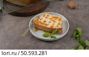 A single, tempting slice of caramelized molotov pudding, drizzled with sweet caramel and garnished with fresh mint leaves, ready to be enjoyed on a small plate with a spoon. Стоковое фото, агентство Ingram Publishing / Фотобанк Лори