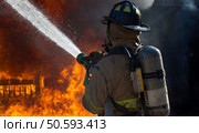 Fireman putting out a bedroom fire. Стоковое фото, агентство Ingram Publishing / Фотобанк Лори