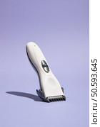 Hair clipper stand on purple background. Idea creative inspiration and hairdressing work. Стоковое фото, агентство Ingram Publishing / Фотобанк Лори