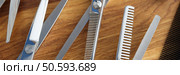 Set of scissors and combs on wooden table. Profession hairdresser concept. Set of scissors and combs on wooden table closeup. Стоковое фото, агентство Ingram Publishing / Фотобанк Лори