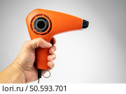 Vintage orange hair dryer on white background with rolled cable buttom. Стоковое фото, агентство Ingram Publishing / Фотобанк Лори