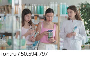 Happy family of adult woman and young girl choosing best toothbrush at big pharmacy and scan QR code on label, female pharmacist consulting and offering variety of goods to customers. Стоковое видео, видеограф Яков Филимонов / Фотобанк Лори