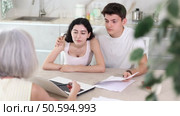 Insurance agent explaining conditions of insurance in home interior. Стоковое видео, видеограф Яков Филимонов / Фотобанк Лори