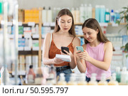 Daughter and mother in summer clothes scans code on pills to check expiration date. Стоковое фото, фотограф Яков Филимонов / Фотобанк Лори