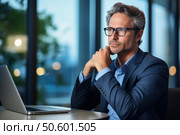 Pensive businessman contemplating in modern office with laptop. Стоковое AI-изображение, AI-художник Иван Рябоконь / Фотобанк Лори