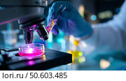 Scientist conducts experiment with colorful liquids under microscope in modern laboratory. Стоковое AI-изображение, AI-художник Сергей Толмачёв / Фотобанк Лори