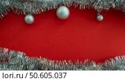 Christmas background with copy space in the center. Christmas balls and tinsel on a red background. Стоковое фото, фотограф Юлия Николаева / Фотобанк Лори