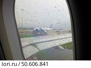 Капли воды на иллюминаторе самолета во время дождя. Пасмурный день. Стоковое фото, фотограф Александр Кузнецов / Фотобанк Лори
