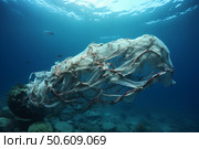 Ocean pollution highlighted by entangled fishing net. Стоковое AI-изображение, AI-художник Иван Рябоконь / Фотобанк Лори