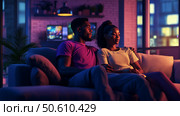 Cozy evening on the couch with friends enjoying a movie night in warm ambient lighting. Стоковое AI-изображение, AI-художник Сергей Толмачёв / Фотобанк Лори