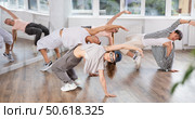 Girl and her students perform hip hop dance on one bent leg, movement in horizontal plane near floor. Стоковое фото, фотограф Яков Филимонов / Фотобанк Лори