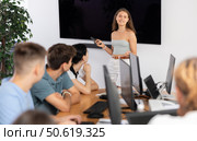Young girl speaker stands in front of students and talks about use of artificial intelligence. Стоковое фото, фотограф Яков Филимонов / Фотобанк Лори