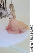 Elegant woman posing in a studio with flowing fabric at a fashion shoot. Стоковое видео, видеограф Гурьянов Андрей / Фотобанк Лори