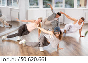 Girl and her students perform hip hop dance on one bent leg, movement in horizontal plane near floor. Стоковое фото, фотограф Яков Филимонов / Фотобанк Лори