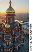 Aerial view of a beautiful Orthodox cathedral with golden domes, overlooking a city skyline at a dramatic sunset. Стоковое AI-видео, аниматор Sergey Grishin / Фотобанк Лори