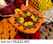 Crochet granny square, clews and hook on crochet blanket background photo. Стоковое фото, фотограф Елена / Фотобанк Лори