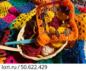 Crochet granny square, clews and hook on crochet blanket background photo. Стоковое фото, фотограф Елена / Фотобанк Лори