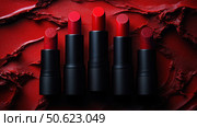 Row of passion red lipsticks displayed against a vibrant red textured background. Beauty industry and fashion concept. Copy space. Advertisement for makeup artists. Стоковое AI-изображение, AI-художник Ирина Михайличенко / Фотобанк Лори