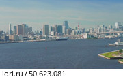 Tokyo, Japan - Oct 2 2024, 4k, panoramic aerial view of Tokyo Bay cityscape in background and the Rainbow Bridge, in the foreground is a part of Odaiba Island with a triangular building, Tokyo, Japan. Стоковое видео, видеограф Сергей Богомяко / Фотобанк Лори