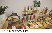A breakfast table is set in a small hotel. Sausages, yogurt, salads, sauces, drinks. Стоковое видео, видеограф Aleksey Kidisyuk / Фотобанк Лори