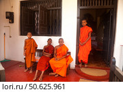 Buddhist Monks in Traditional Attire at a Temple in Sri Lanka Enjoying the Outdoors. Редакционное фото, фотограф Aleksandr Golubev / Фотобанк Лори