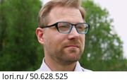 Confident Businessman in Natural Setting. Man stands in front of lush green backdrop. Remote working. Portrait of happy mid adult male wearing formal clothes, shirt and tie, glasses. Find inspiration. Стоковое видео, видеограф Марина Демидюк / Фотобанк Лори
