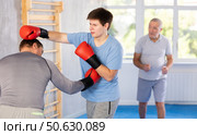 Guy getting blow to body in boxing sparring at self-defense training. Стоковое фото, фотограф Яков Филимонов / Фотобанк Лори