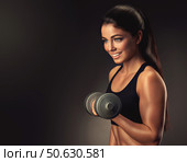 Beautiful fitness woman with lifting dumbbells . Sporty girl showing her well trained body . Well-developed muscles by strength training . Стоковое фото, фотограф Sofia Zhuravetc / Фотобанк Лори