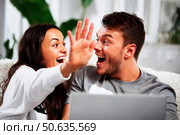 A man and woman are hugging and laughing while looking at a laptop. Стоковое AI-изображение, AI-художник Ярославский Максим / Фотобанк Лори