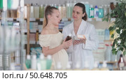 Pregnant woman choosing syrup with help of pharmacist. Стоковое видео, видеограф Яков Филимонов / Фотобанк Лори