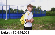 A first grader boy with a backpack goes to school on September 1. Стоковое видео, видеограф Igor Skripachev / Фотобанк Лори