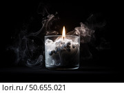 Extinguished candle emitting smoke in glass jar on black background. Стоковое AI-изображение, AI-художник Иван Рябоконь / Фотобанк Лори