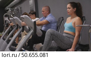 Woman riding cardiovascular trainers in modern gym. Стоковое видео, видеограф Яков Филимонов / Фотобанк Лори