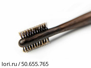 Small round wooden brush with boar bristles lying on white background. Стоковое AI-изображение, AI-художник Иван Рябоконь / Фотобанк Лори