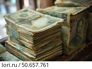 Stacks of chinese yuan banknotes showing mao zedong sitting on a wooden surface. Стоковое AI-изображение, AI-художник Иван Рябоконь / Фотобанк Лори