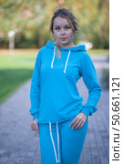 Smiling girl in blue tracksuit on street looking at camera. Стоковое фото, фотограф Роготнева Виктория / Фотобанк Лори