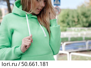 Smiling girl in green tracksuit on street looking at camera. Стоковое фото, фотограф Роготнева Виктория / Фотобанк Лори