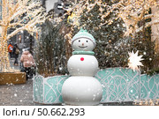 Holiday snowmen on the streets of Moscow. Christmas background with a snowman. Concept of preparation and decoration for the New Year. New Year's postcard 2026. Стоковое фото, фотограф Photojuli / Фотобанк Лори