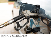 Gas station. Refueling a car with gasoline. Fuel dispenser in the car's fuel tank at a gas station. Rising fuel prices worldwide. Стоковое фото, фотограф Photojuli / Фотобанк Лори