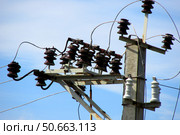Electrical cables and ceramic, porcelain insulators of high voltage transmission line on top of concrete pole. Стоковое фото, фотограф Виталий Борисов / Фотобанк Лори