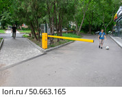 Автоматический шлагбаум  и мальчик с мячом на въезде к жилому комплексу в Пятигорске. Редакционное фото, фотограф Лариса Веселова / Фотобанк Лори