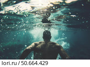 Man diving underwater, exploring the depths of the ocean. Стоковое AI-изображение, AI-художник Иван Рябоконь / Фотобанк Лори