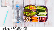 Lunchbox with sandwich, chorizo, cucumber and peach, bottle of water top view web banner. Стоковое фото, фотограф Елена Руй / Фотобанк Лори