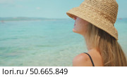 Closeup of woman in sunhat enjoying serene beach moment, symbolizing mindful summer lifestyle. Стоковое видео, видеограф Igor Tichonow / Фотобанк Лори