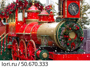 Christmas locomotive on the street of Moscow. New Year's postcard 2026. Beautiful Christmas background with a train. Concept of preparing decorations and attire for the New Year. Стоковое фото, фотограф Photojuli / Фотобанк Лори