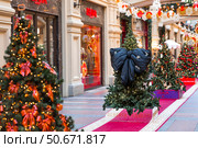 Stylish black bow on the Christmas tree. Beautiful Christmas background. Concept of preparing decorations and furnishings for the New Year. New Year's card 2026. Стоковое фото, фотограф Photojuli / Фотобанк Лори