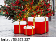 Fabulous Christmas background. Festive toys and gift boxes on the New Year tree in Moscow. The concept of decorations for the holiday. New Year's card 2026. Стоковое фото, фотограф Photojuli / Фотобанк Лори