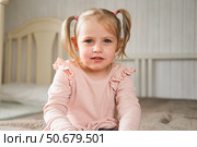 Little Girl joking sticking tongue out with silly expression. Child making face. Funny foolishness portrait of baby girl laughing in bedroom. Adorable Caucasian kid doing crazy comical gesture at home. Стоковое фото, фотограф Марина Демидюк / Фотобанк Лори